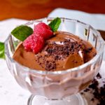 Chocolate Pudding in glass dessert dish, garnished with fresh raspberries and mint>