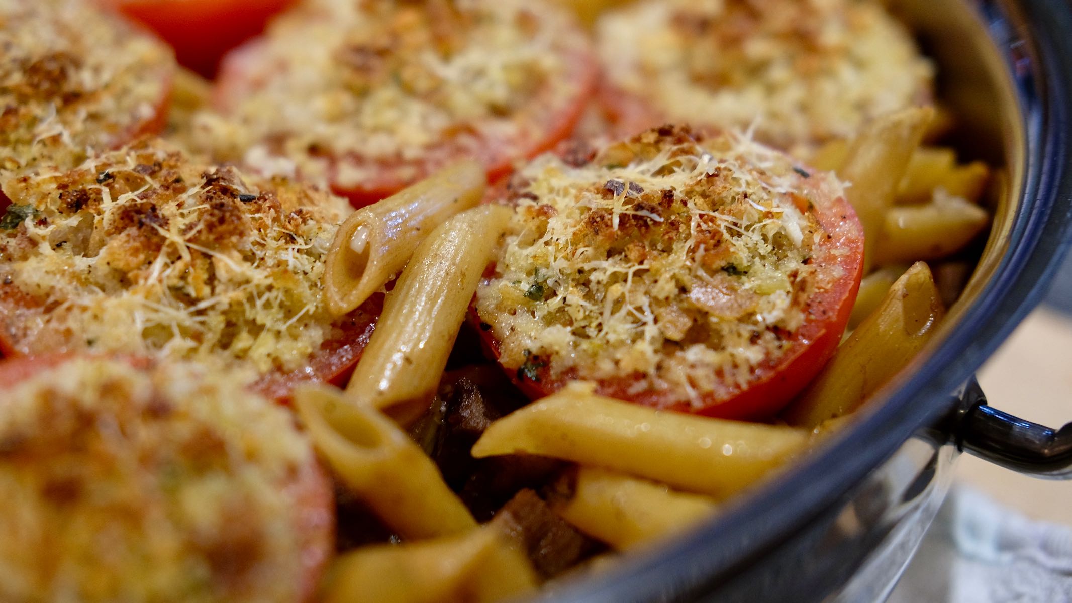 Pasta Tiella in baking pan with Stuffed Tomatoes