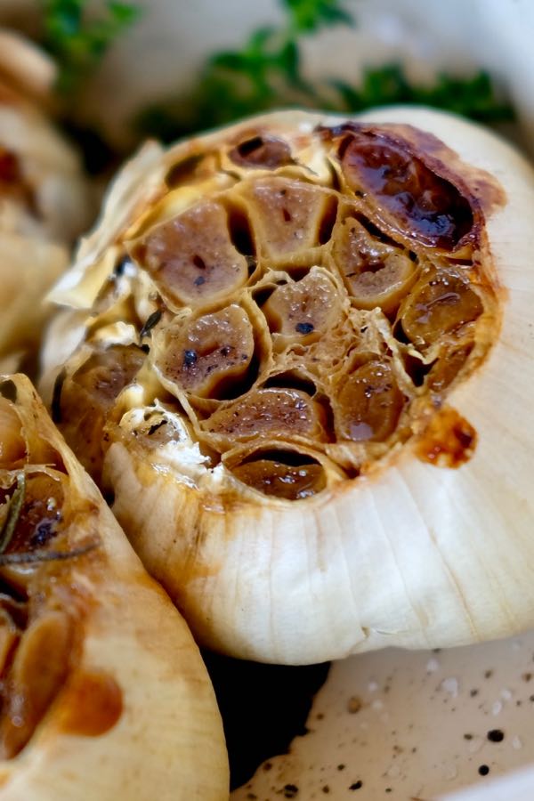 Heads of Roasted Garlic with fresh thyme in background.
