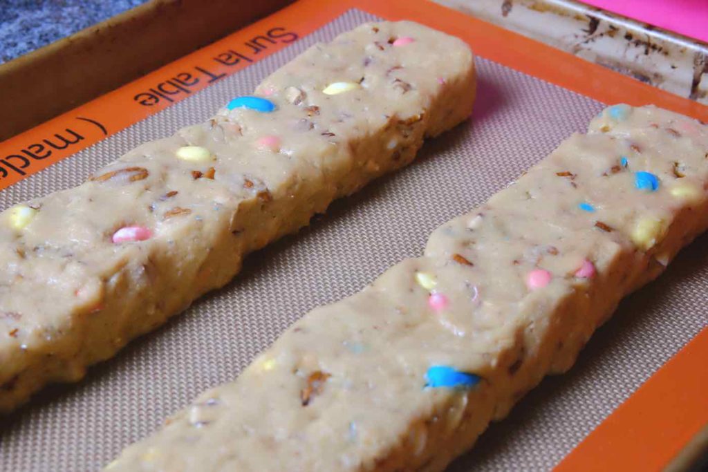 Biscotti dough shaped into a log by hand on baking pan lined with Silpat.