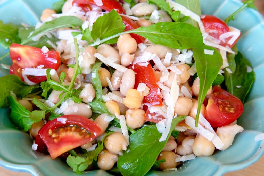 Bean and Tomato Salad in blue bowl garnished with Grana Padano