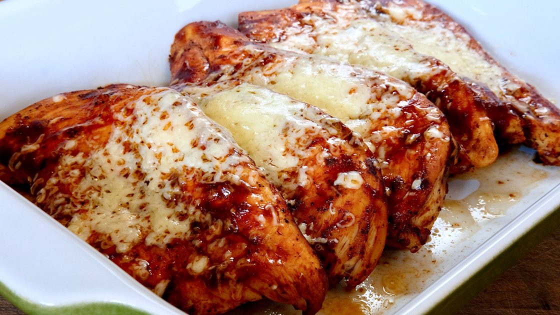 Guajillo Chili Chicken garnished with sauce and melted cheese