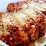 Guajillo Chili Chicken garnished with sauce and melted cheese