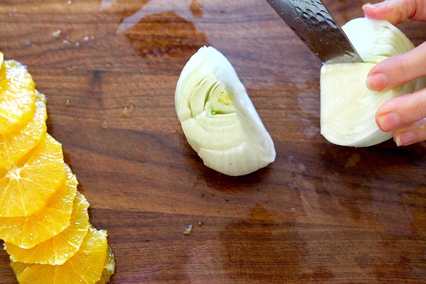 Coring the Fennel Bulb with sliced oranges off to the side of cutting board.