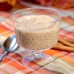 Cinnamon Tapioca Pudding is glass serving dish with cinnamon sticks in background and spoon to the side of dish.