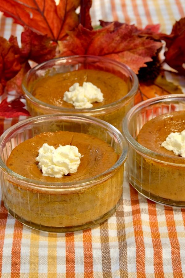 Pumpkin Custard Cups on fall plaid overlay with fall leaves in background