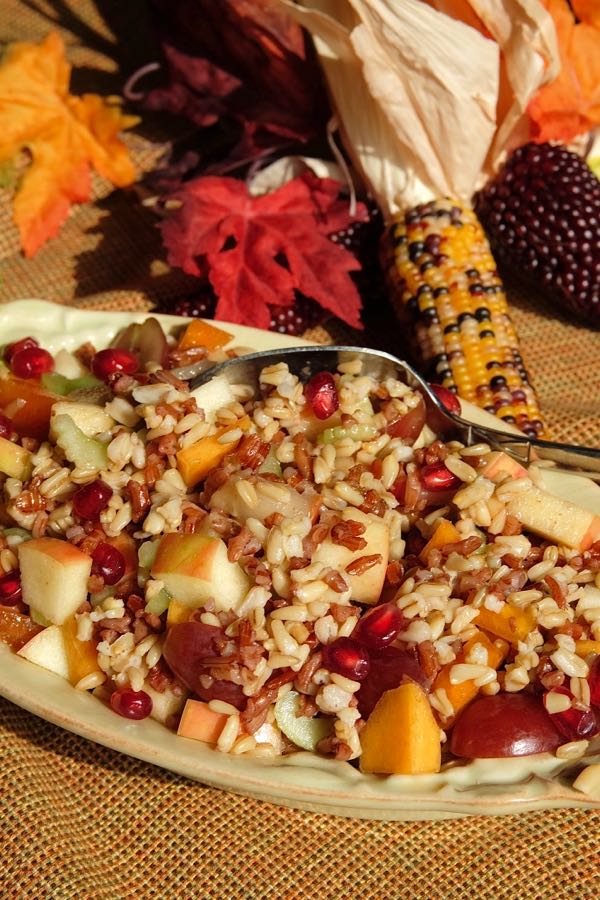 Bountiful Harvest Grain Salad in serving boat with Thanksgiving centerpiece of corn and leaves in background.