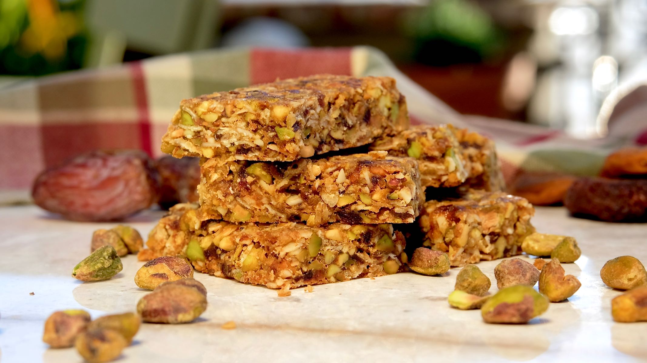 Granola bars on white marble slab with burgundy and green plaid linen in background.