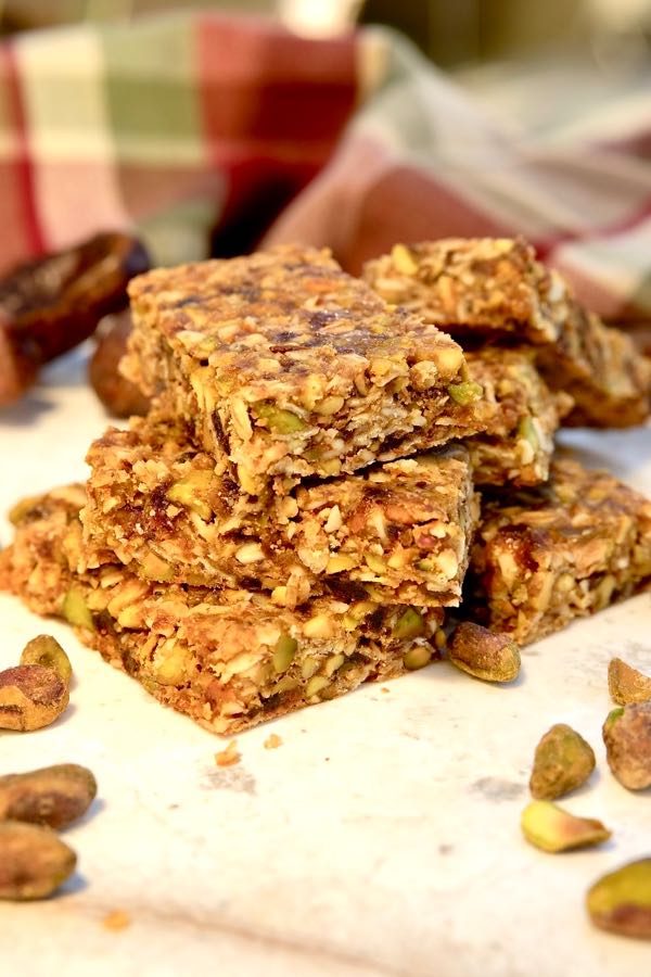 Pistachio-Apricot Granola Bars on white marble with red and green plaid linen in background