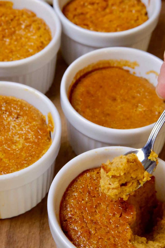 Pumpkin Custard Cups with spoonful of pumpkin custard in foreground.