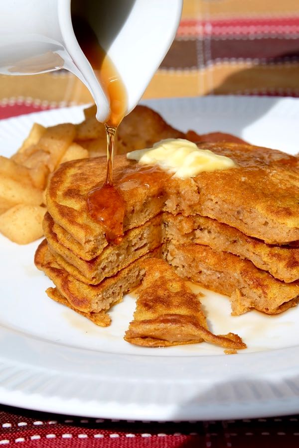 Fluffy Pumpkin Spice Pancakes with syrup and Sauteed Cinnamon Apples on white plate