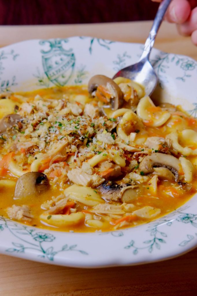 Green and white Italian bowl with Turkey Tetrazzini Soup and garnished with Toasted Gremolata Breadcrumbs.