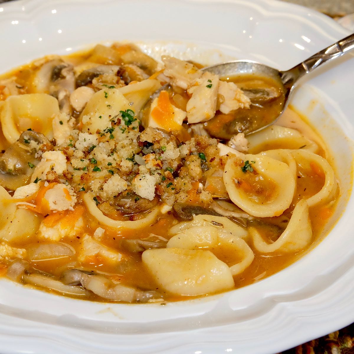 Turkey Tetrazzini Soup in white soup bowl topped with Toasted Breadcrumb Gremolata