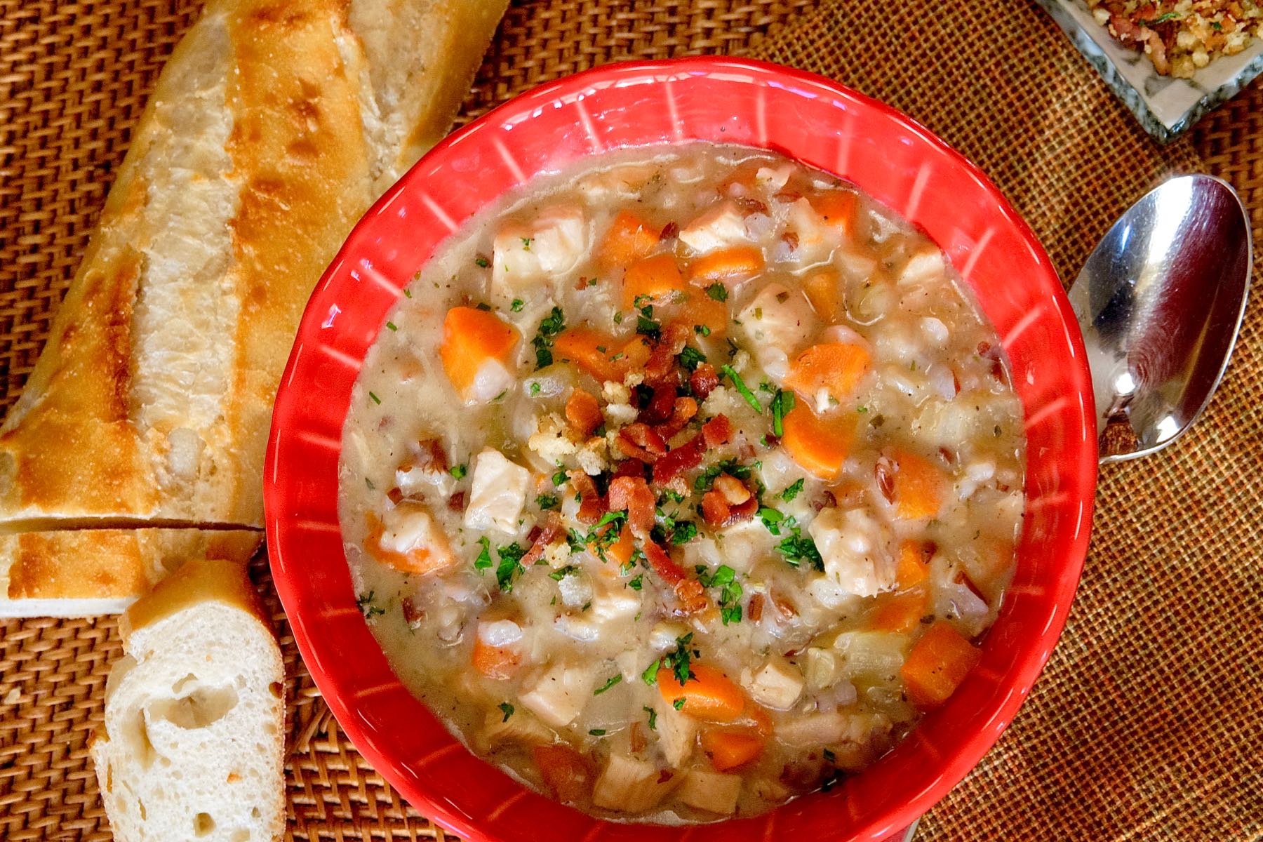 Hearty Turkey Chowder in Red Bowl served with french baguette