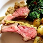 Herb Crusted Rack of Lamb with potatoes and broccoli on white plate