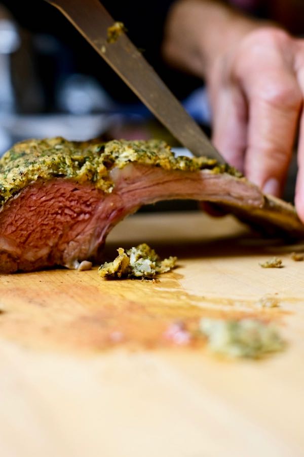 Herb-Crusted Rack of Lamb being cut into serving portions.