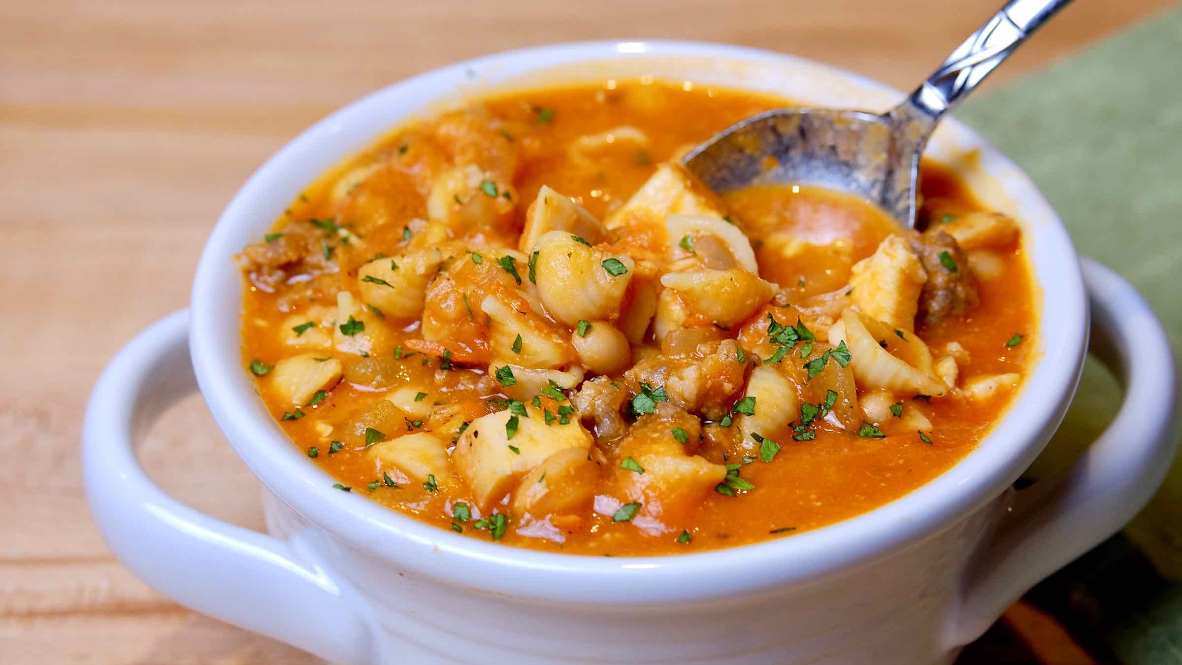 Tuscan Bean Soup in white bowl with a spoonful of soup