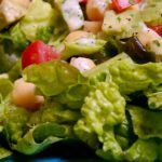 Green Mediterranean Salad on blue plate with Lemon-Sumac Dressing and yogurt sauce.