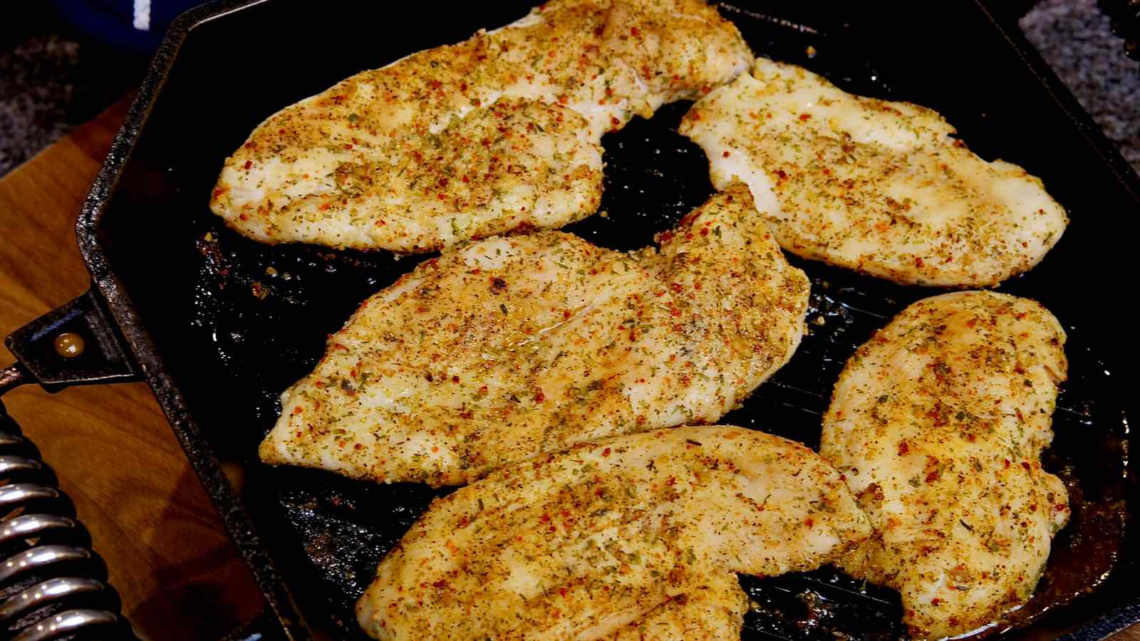 Easy Baked Chicken Cutlets in cast iron grill pan seasoned with Tuscan Seasoning