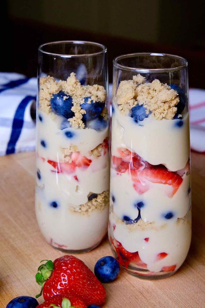 Red, White and Blue Berry Parfaits in tall parfait glasses with red and blue plaid linen in background.