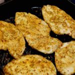 Easy Baked Chicken Cutlets in cast iron pan with Tuscan Seasoning.
