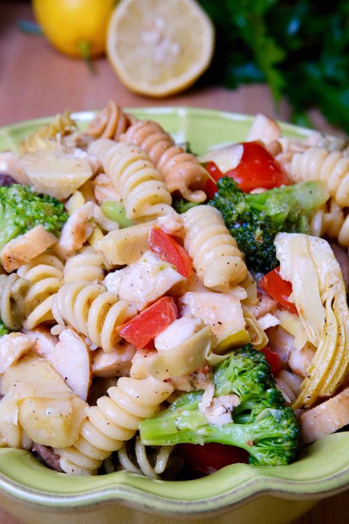 Pasta Salad made with rotini pasta, broccoli, artichoke, tomato, cheese and chopped chicken.  