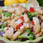 Pasta Salad Italian Style in green seving bowl with lemons in background.