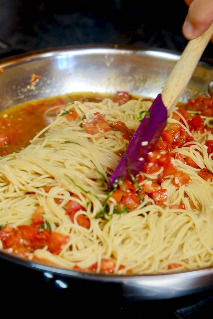 Linguine and fresh tomato sauce simmering together in saute pan.