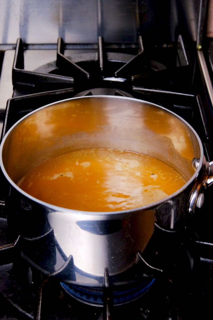 Hot broth in stainless steel pan.