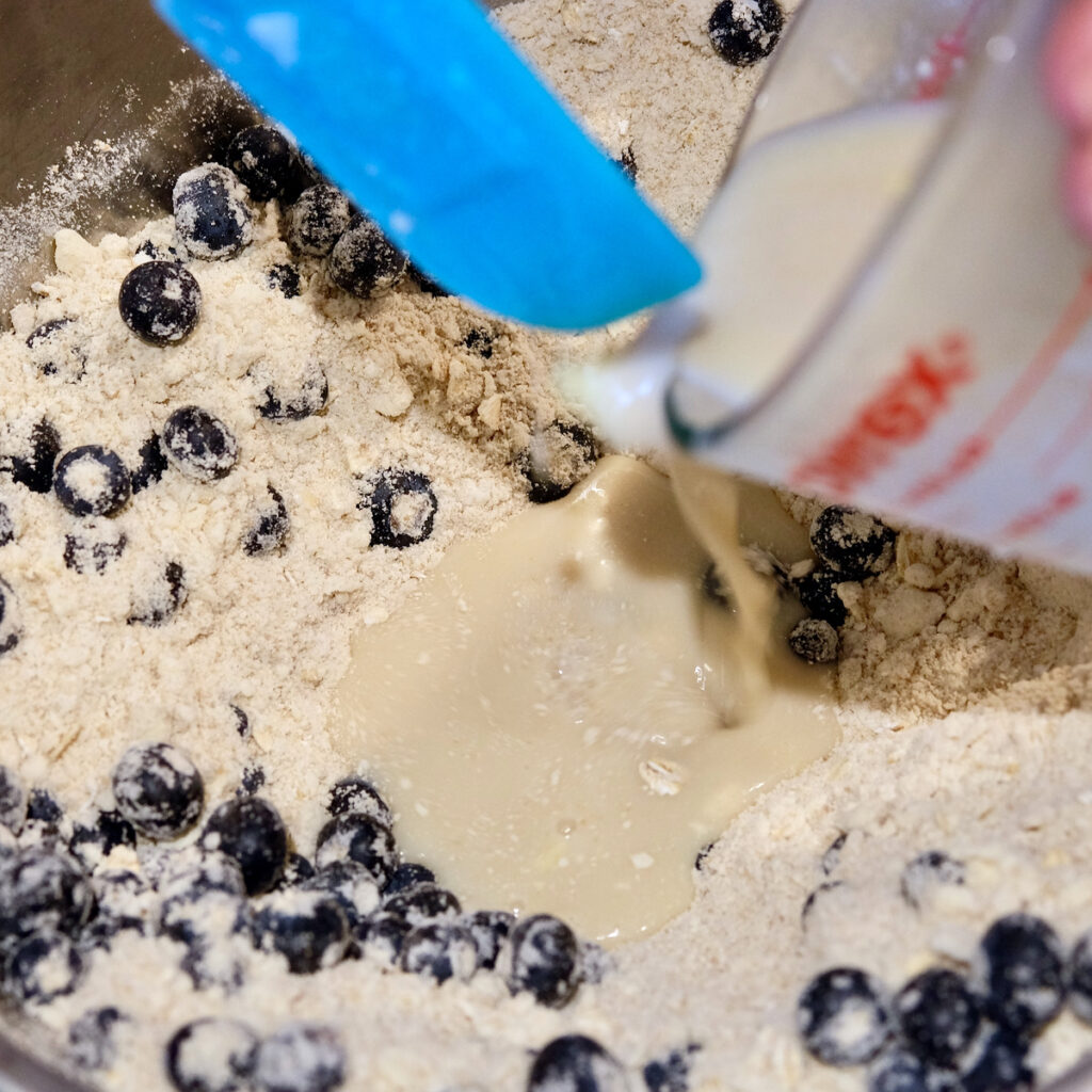 Liquid ingredients being poured into a well in the center of dry ingredients.